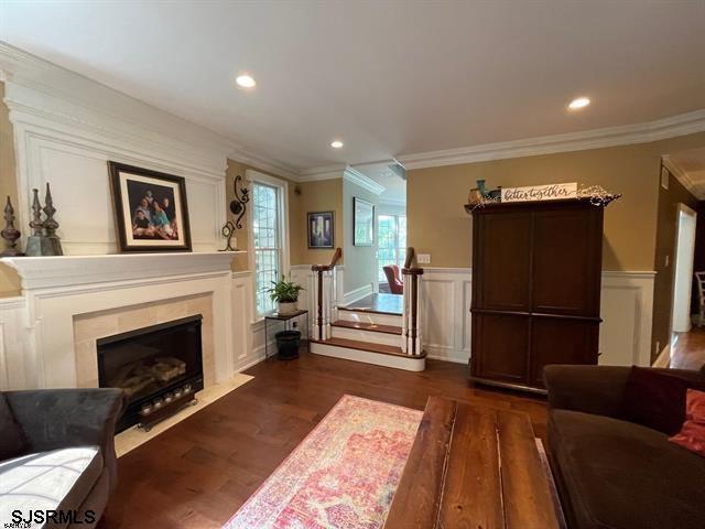 living room with dark hardwood / wood-style flooring and ornamental molding