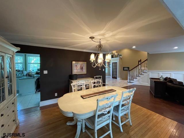 dining room featuring hardwood / wood-style flooring, crown molding, and an inviting chandelier