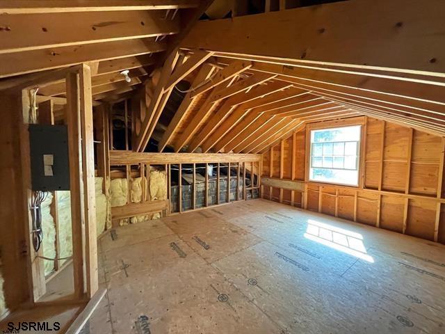 unfinished attic featuring electric panel