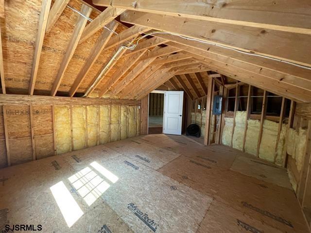 attic featuring electric panel