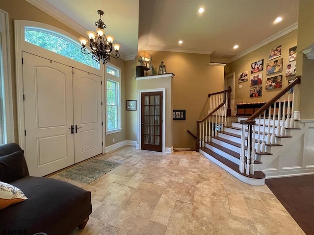 entrance foyer with a healthy amount of sunlight, a chandelier, and ornamental molding