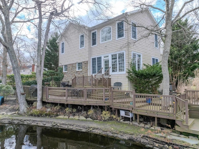 rear view of house with a deck with water view