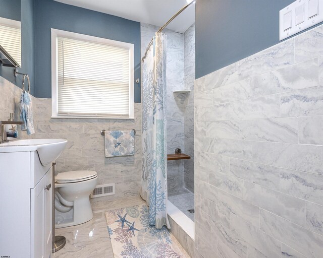 bathroom with toilet, vanity, walk in shower, and tile walls