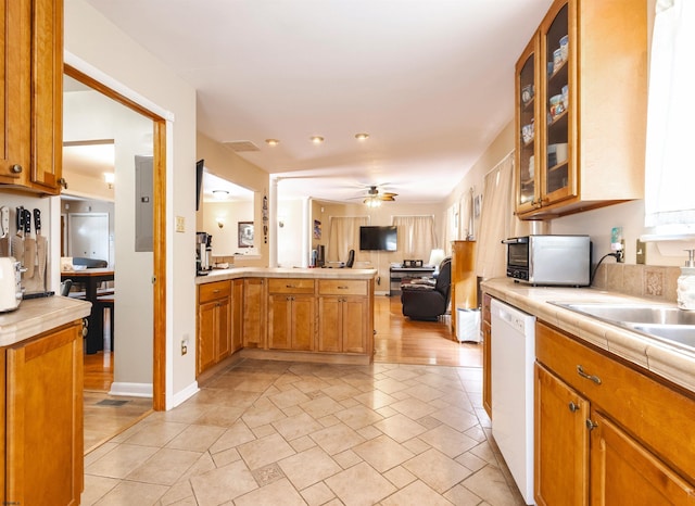 kitchen featuring kitchen peninsula, dishwasher, ceiling fan, electric panel, and tile counters