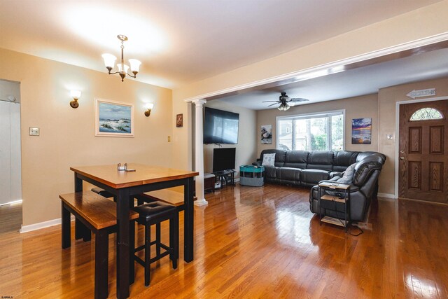 dining room with hardwood / wood-style flooring and ceiling fan with notable chandelier