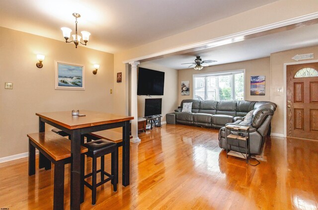 living room with wood-type flooring and ceiling fan with notable chandelier