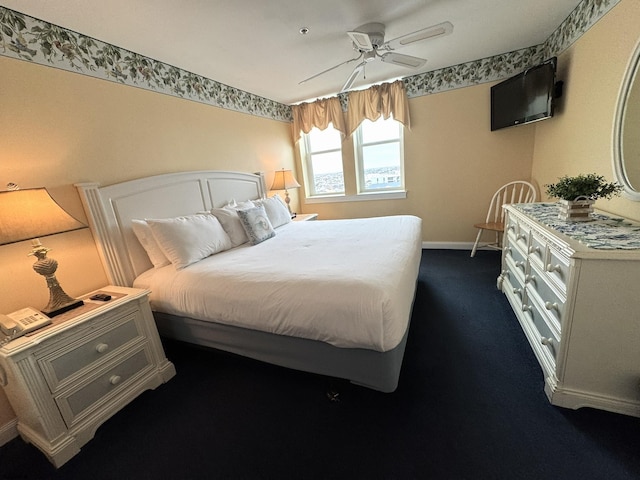 bedroom featuring ceiling fan and dark carpet