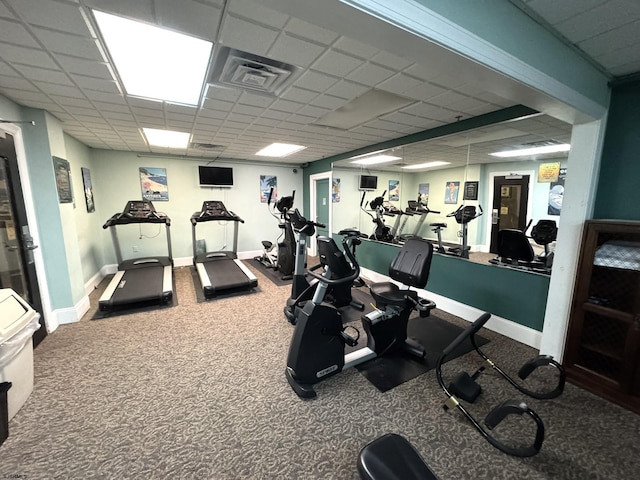 gym featuring carpet flooring and a paneled ceiling