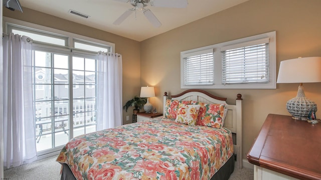 carpeted bedroom with visible vents, a ceiling fan, and access to outside