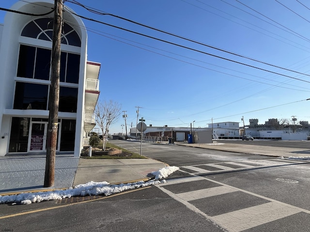 view of road featuring traffic signs, curbs, and sidewalks