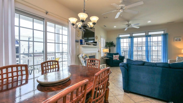 dining area with a notable chandelier, light tile patterned floors, a fireplace, and recessed lighting