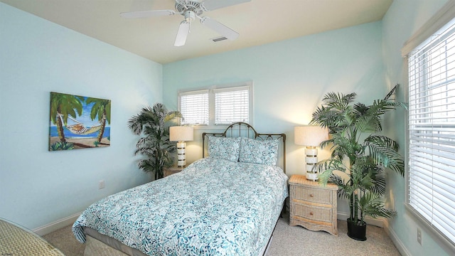 carpeted bedroom featuring visible vents, baseboards, and a ceiling fan