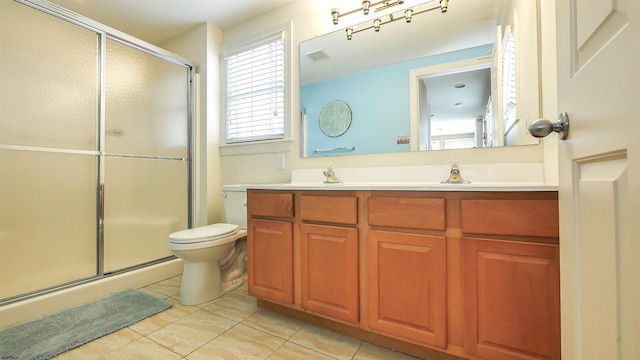 bathroom featuring a shower stall, toilet, double vanity, tile patterned floors, and a sink