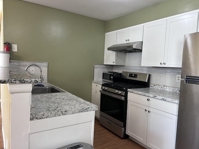 kitchen with tasteful backsplash, white cabinetry, dark hardwood / wood-style flooring, and appliances with stainless steel finishes