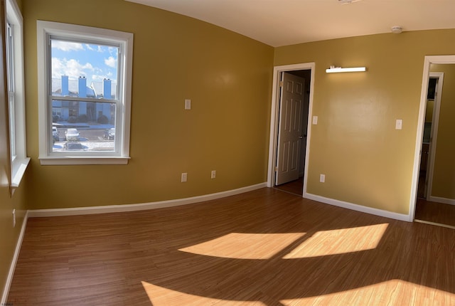 unfurnished room with dark wood-type flooring