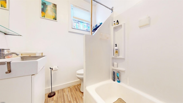 full bathroom with hardwood / wood-style flooring, vanity, toilet, and  shower combination