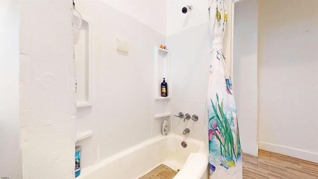 bathroom featuring wood-type flooring and shower / tub combo with curtain