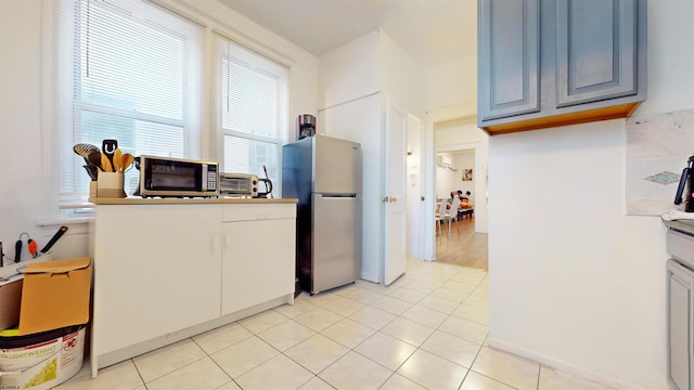 kitchen featuring appliances with stainless steel finishes, gray cabinets, and light tile patterned floors