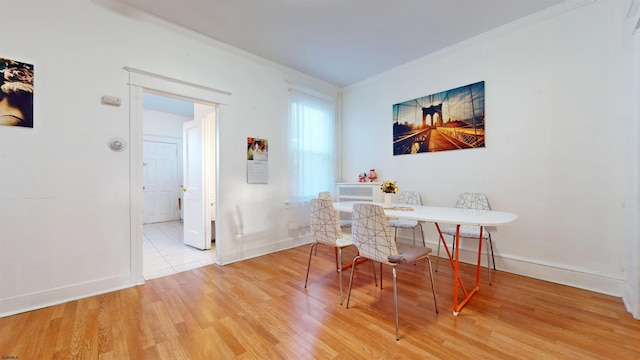 dining room featuring crown molding and light hardwood / wood-style flooring