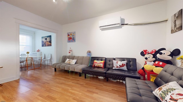 living room with an AC wall unit and light hardwood / wood-style flooring