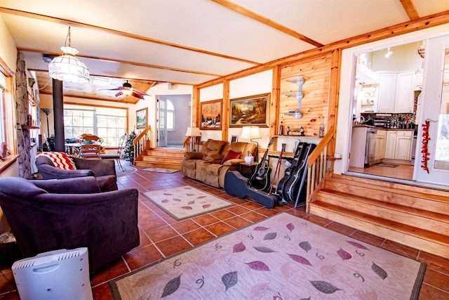 living room featuring ceiling fan, beam ceiling, and dark tile patterned floors