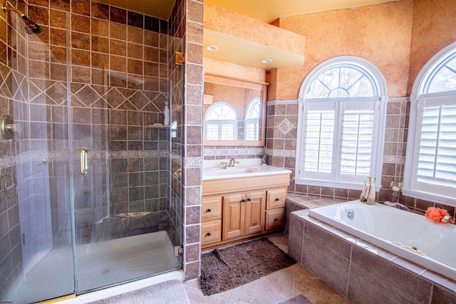 bathroom with plenty of natural light, tile patterned flooring, vanity, and tile walls