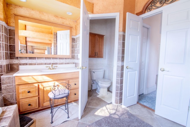 bathroom featuring tile patterned flooring, vanity, and toilet