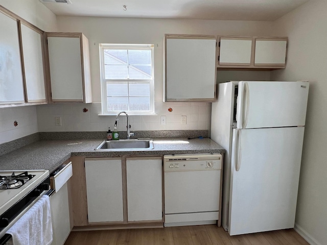 kitchen with sink, white appliances, light hardwood / wood-style flooring, backsplash, and white cabinets