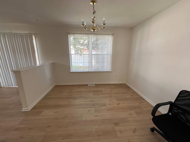 dining area featuring a notable chandelier and light wood-type flooring