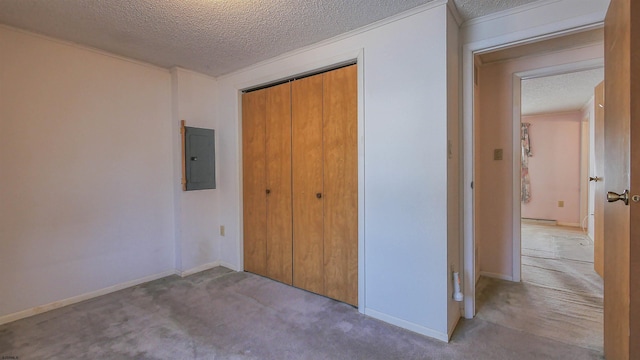 unfurnished bedroom featuring light colored carpet, electric panel, a closet, and a textured ceiling