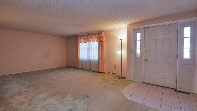 carpeted entrance foyer featuring a textured ceiling