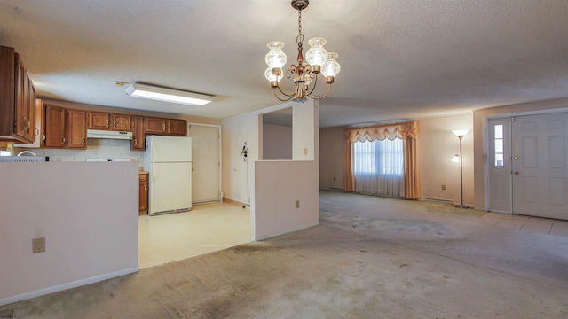 kitchen featuring white refrigerator, decorative light fixtures, light carpet, and a textured ceiling