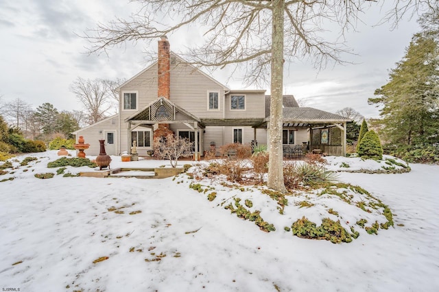 view of snow covered back of property