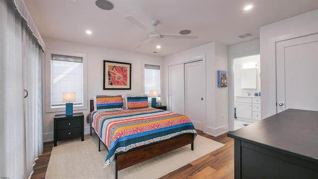 bedroom with hardwood / wood-style flooring, ceiling fan, ensuite bathroom, and a closet