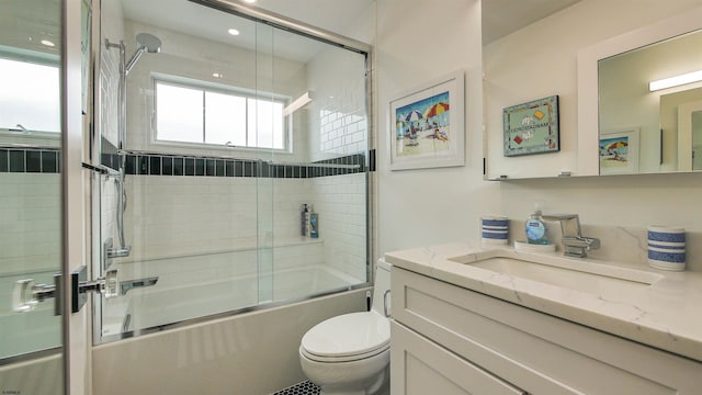 full bathroom featuring vanity, toilet, and combined bath / shower with glass door