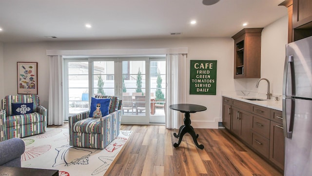 interior space featuring dark wood-type flooring, sink, french doors, and a wealth of natural light