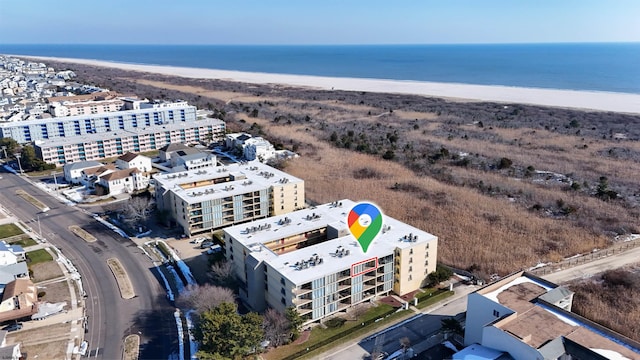 drone / aerial view featuring a beach view and a water view