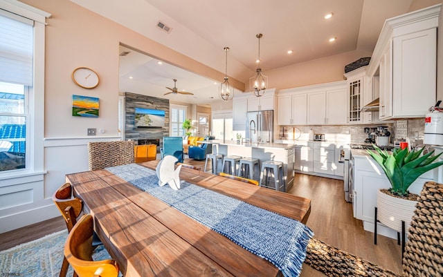 dining room featuring dark wood-type flooring, ceiling fan, and vaulted ceiling