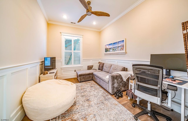 home office with crown molding, ceiling fan, and light hardwood / wood-style flooring