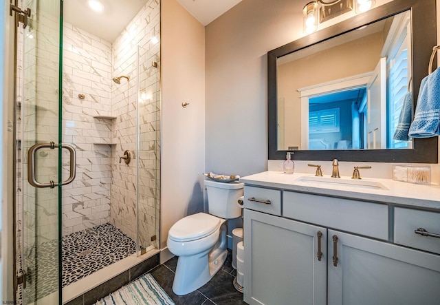 bathroom featuring tile patterned flooring, vanity, toilet, and walk in shower