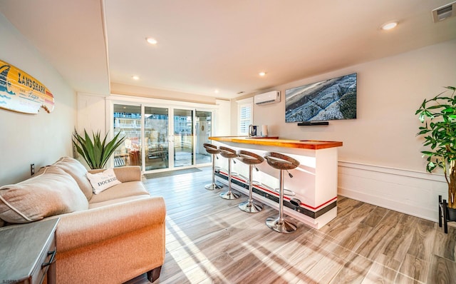 bar with butcher block countertops, wood-type flooring, and a wall mounted AC