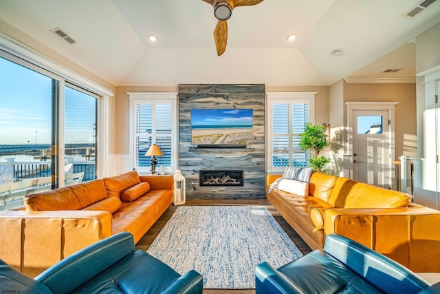 living room featuring lofted ceiling, a tiled fireplace, and plenty of natural light