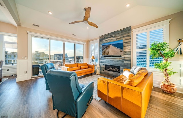 living room with ceiling fan, lofted ceiling, a fireplace, and light wood-type flooring