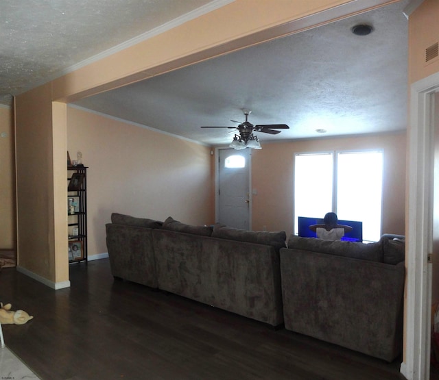 living room featuring dark wood-type flooring, ceiling fan, crown molding, and a textured ceiling