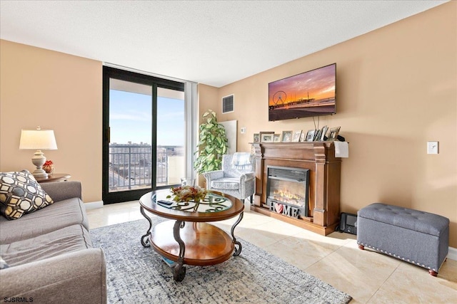 living room featuring expansive windows, a textured ceiling, and light tile patterned floors