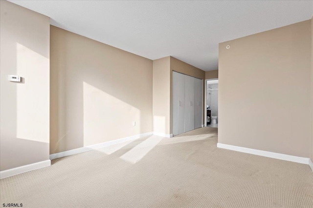 unfurnished room featuring light colored carpet