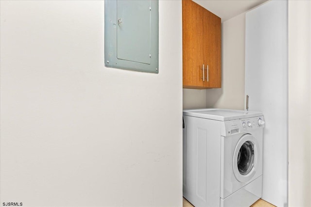 clothes washing area with washer / dryer, electric panel, and cabinets