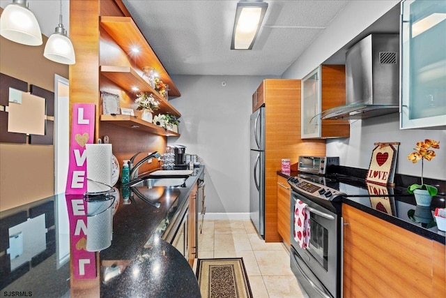 kitchen with pendant lighting, sink, light tile patterned floors, stainless steel appliances, and wall chimney exhaust hood