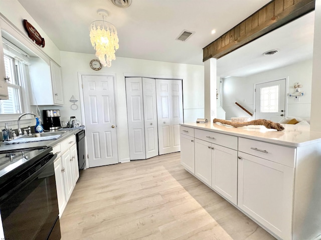 kitchen with white cabinetry, light hardwood / wood-style flooring, hanging light fixtures, plenty of natural light, and black appliances