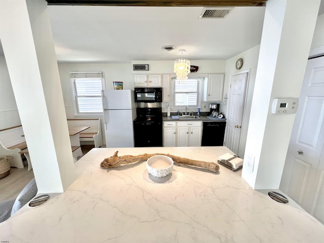 kitchen featuring white cabinetry, sink, a wealth of natural light, and black appliances